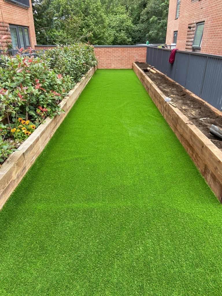 Finished artificial lawn between raised timber sleeper beds